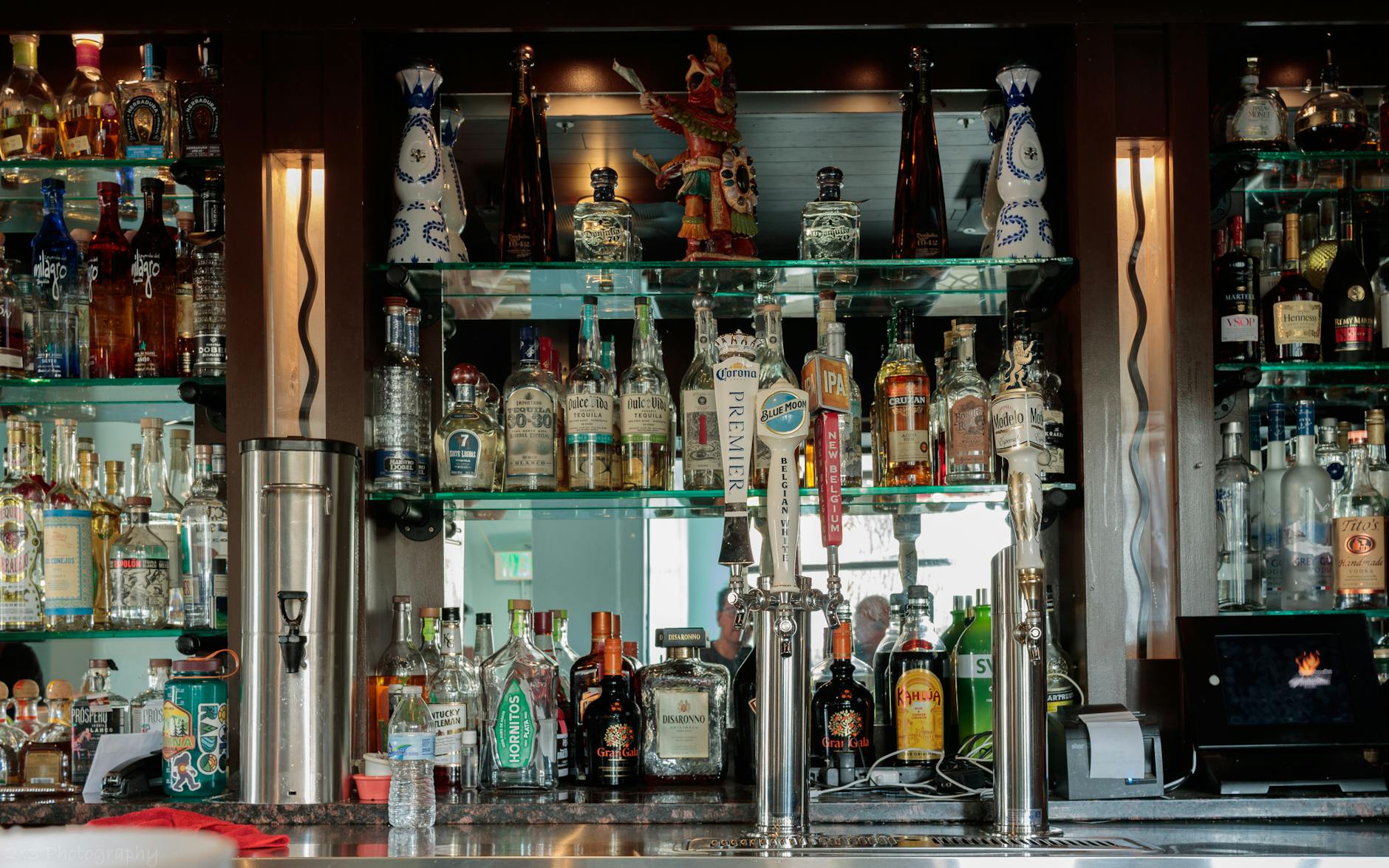 Vibrant bar atmosphere with warm lighting and well-stocked shelves