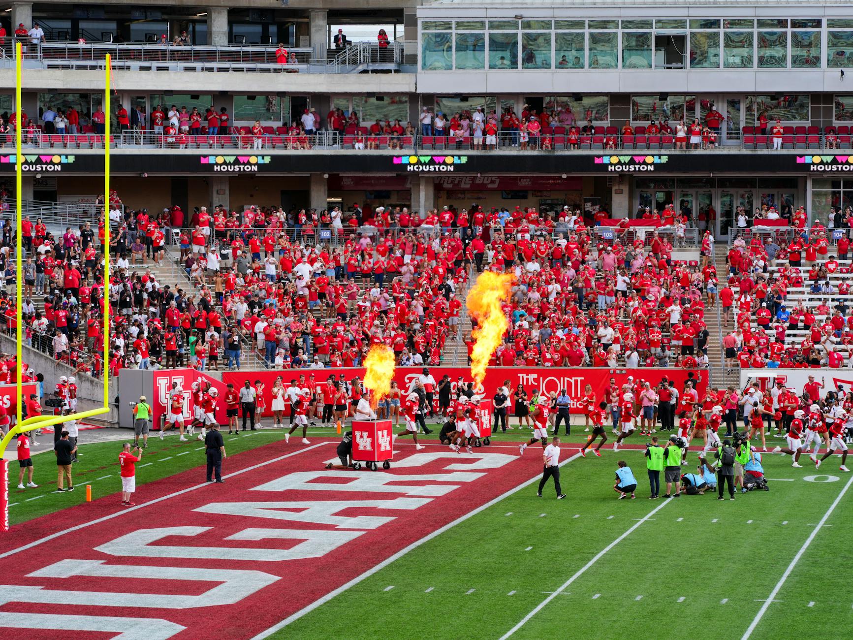 Packed college football stadium during an exciting game with crowd cheering